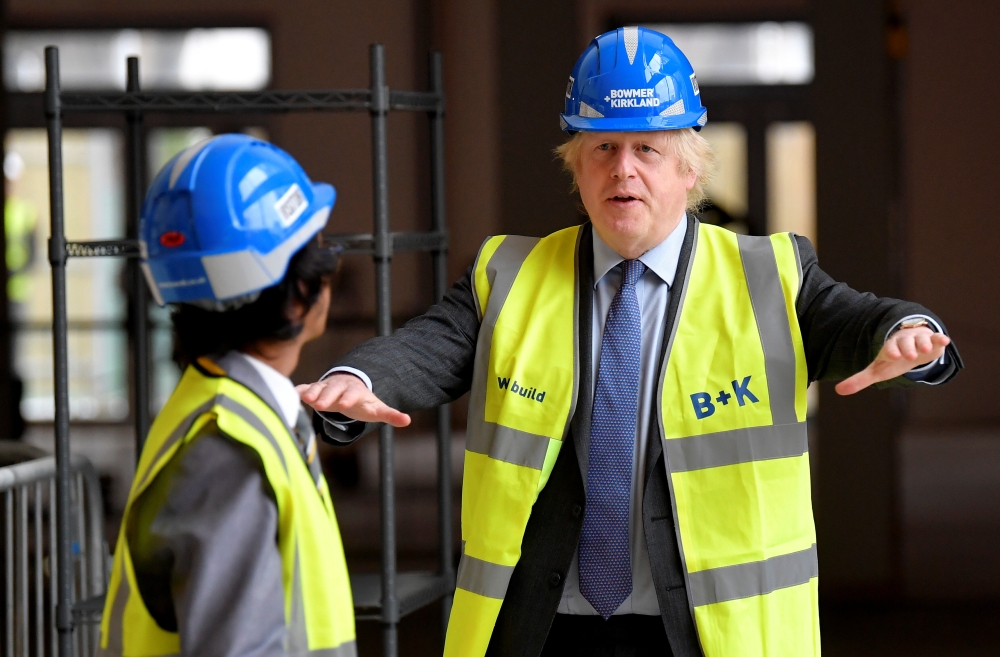 Britain's Prime Minister Boris Johnson talks with year-ten pupil Vedant Jitesh as he visits the construction site of Ealing Fields High School, in west London, Britain, June 29, 2020. REUTERS/Toby Melville/Pool