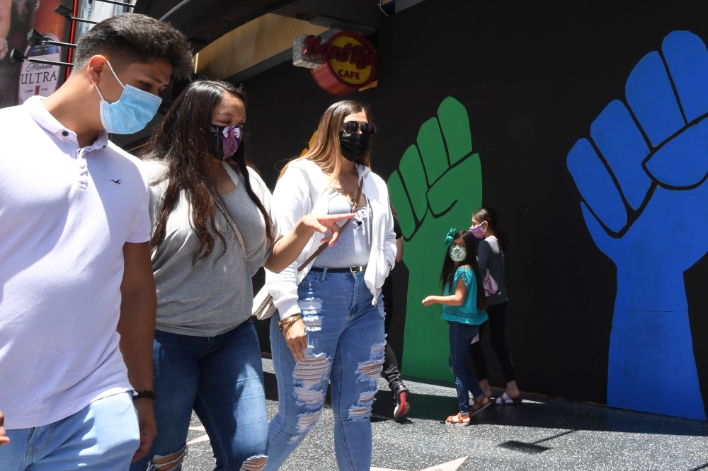 :People wearing masks visit the Hollywood Walk of Fame in Hollywood, California June 30, 2020. Due to a spike in coronavirus cases California Gov. Gavin Newsom ordered the closure of bars in Los Angeles and six other California counties in order to stem t