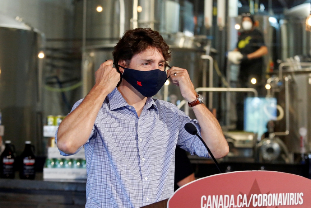 FILE PHOTO: Canada's Prime Minister Justin Trudeau removes his face mask as he visits the Big Rig Brewery, which utilizes the Canada Emergency Wage Subsidy given to businesses affected by the coronavirus disease (COVID-19) outbreak, in Kanata, Ontario, Ca