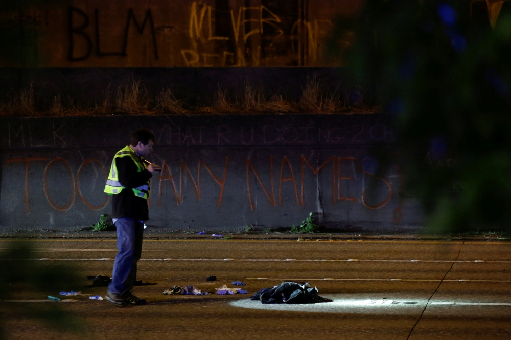 Washington State Patrol investigator inspects the scene where two people in a group of protesters were struck by a car on Interstate 5 while the highway was closed to traffic due to the protest in Seattle, Washington, U.S. REUTERS/Jason Redmond