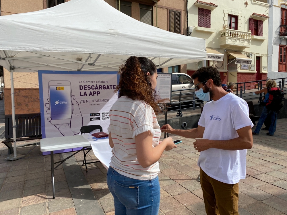Volunteers show residents how to install an app to trace contacts with people potentially infected with the coronavirus disease (COVID-19) being trialled on the Canary Island of La Gomera, Spain, July 3, 2020. Alejandro Noda/via REUTERS 