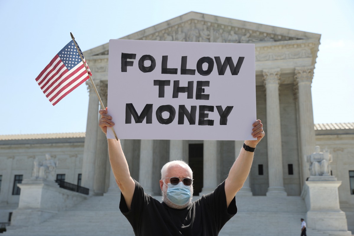 Bill Christeson holds a sign reading 
