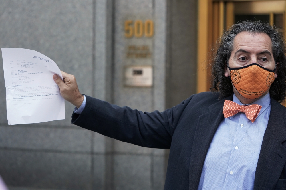 Attorney for Michael Cohen, Jeffrey Levine holds up a document as he tells the media Cohen has been remanded outside Federal Court in the Manhattan Borough of New York City, New York, U.S., July 9, 2020. REUTERS/Carlo Allegri
