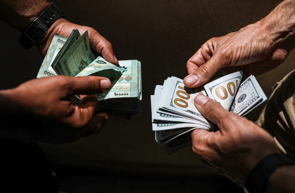 (FILES) In this file photo taken on June 18, 2020, people exchange Lebanese pound and US dollar notes on the black market in Lebanon's capital Beirut. AFP / JOSEPH EID