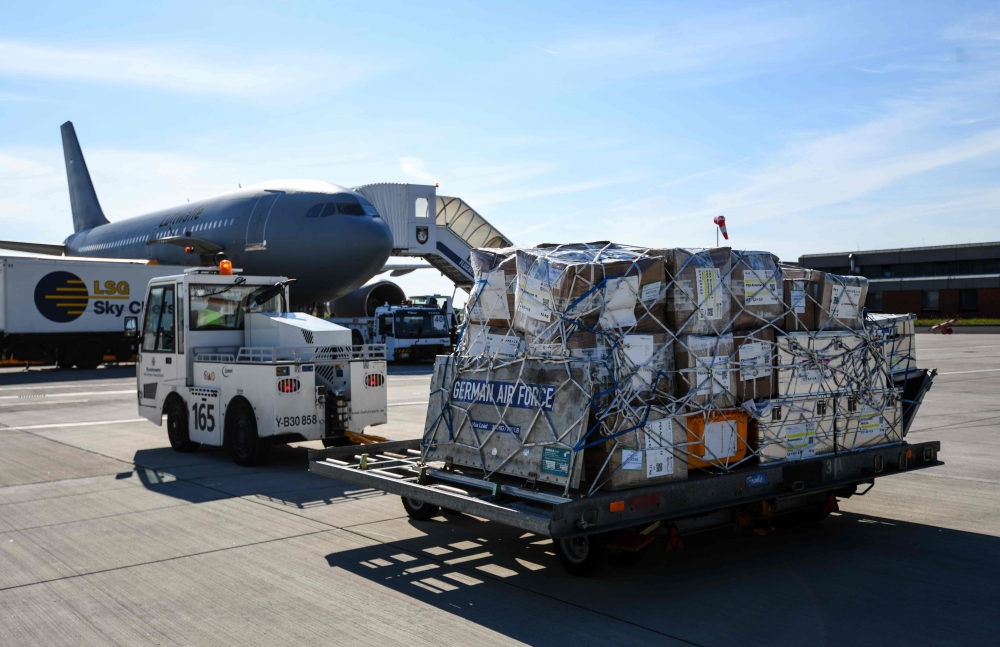 A soldat of the German Air Force puts medical equipment into an Airbus A310 of the German armed forces Bundeswehr before a flight to Armenia at the military part of the airport in Cologne, western Germany, on July 13, 2020.  AFP / Ina FASSBENDER