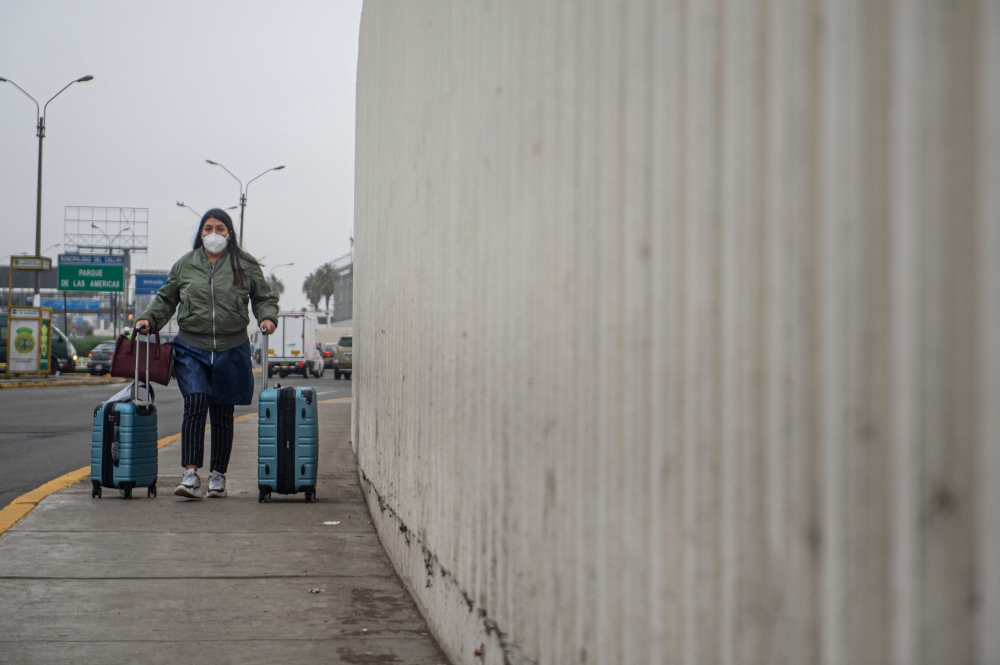 A passenger arrives at Jorge Chavez International Airport in Lima on July 15, 2020 as airports across Peru reopened for domestic flights as part of the easing of measures against the COVID-19 novel coronavirus pandemic. / AFP / Ernesto BENAVIDES
