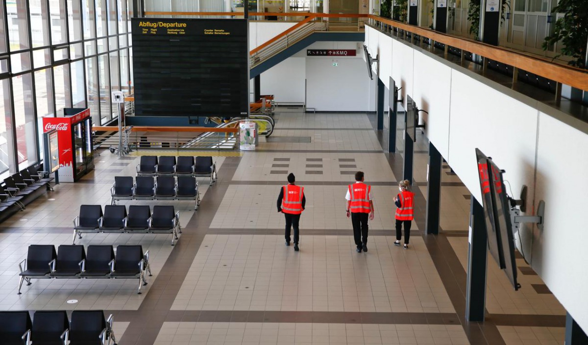 FILE PHOTO:Staff walks through an empty departure lounge at the Berlin Schoenefeld airport, amid the spread of the coronavirus disease (COVID-19) in Schoenefeld, Germany, May 26, 2020. REUTERS/Fabrizio Bensch
