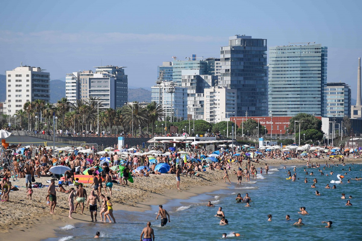 People swim and sunbathe at the Bogatell beach in BARCELONA, one of the several sands of the city that have been closed on July 19, 2020 due to reaching the allowed capacity. / AFP / Josep LAGO
