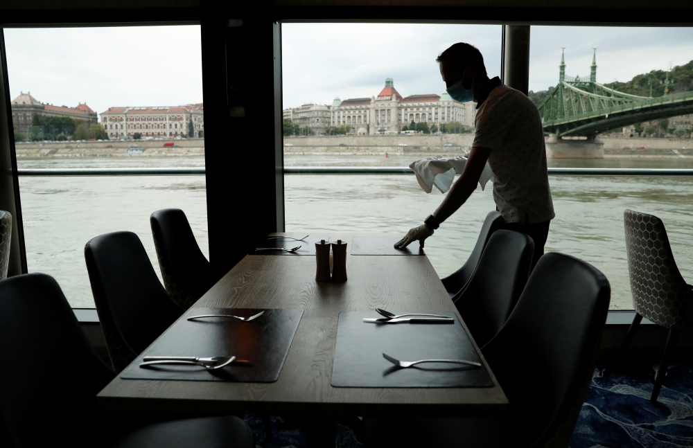 A crew member prepares a table on the NickoVision river cruise boat following the coronavirus disease (COVID-19) outbreak in Budapest, Hungary, July 16, 2020. Picture taken July 16, 2020. REUTERS/Bernadett Szabo