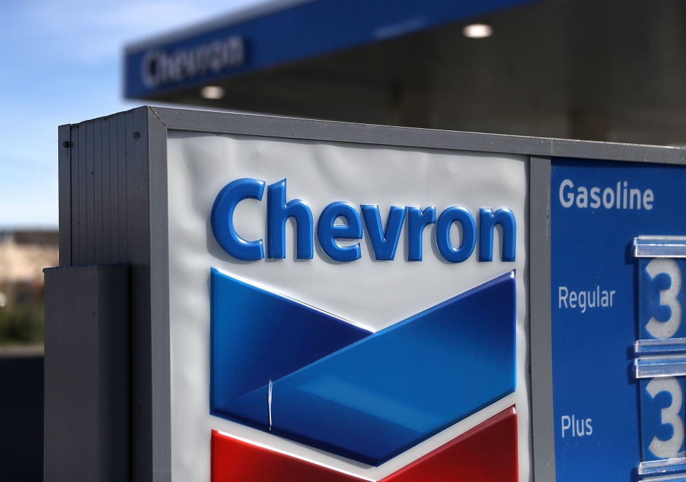 In this file photo a sign is posted in front of a Chevron gas station on February 2, 2018 in Corte Madera, California. Chevron said July 20, 2020 it had agreed to buy US exploration and production company Noble Energy for $5 billion, the biggest petroleum