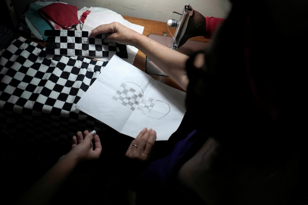 Sofia Valenzuela shows a tailor a drawing of a mask she would like to wear during a photo session for her quinceanera (coming of age of 15-year-olds) celebration amid coronavirus disease (COVID-19) spread concerns, in Havana, Cuba, July 14, 2020. Picture 