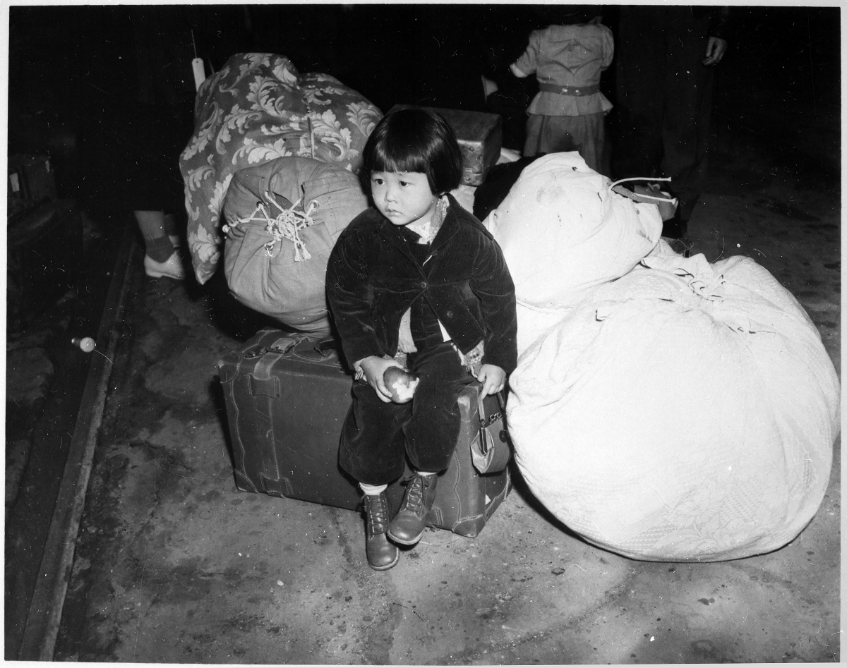This photo obtained July 21, 2020 courtesy of the US National Archives shows two-year-old Yuki Okinaga Hayakawa, an evacuee of Japanese ancestry waiting with the family baggage before leaving by bus for an assembly center in the spring of 1942, taken by W