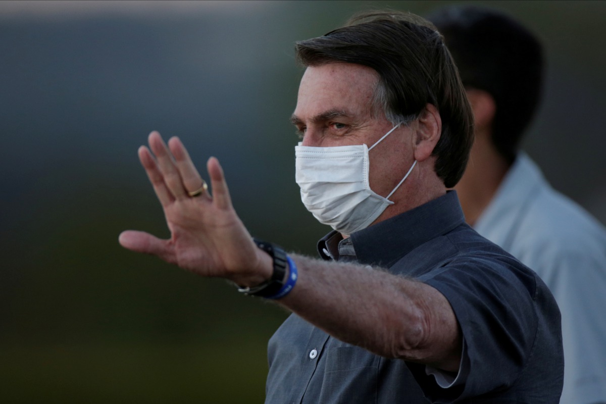 FILE PHOTO: Brazil's President Jair Bolsonaro gestures during a ceremony to lower the Brazilian National flag down for the night, at the Alvorada Palace, amid the coronavirus disease (COVID-19) outbreak, in Brasilia, Brazil, July 20, 2020. REUTERS/Ueslei 