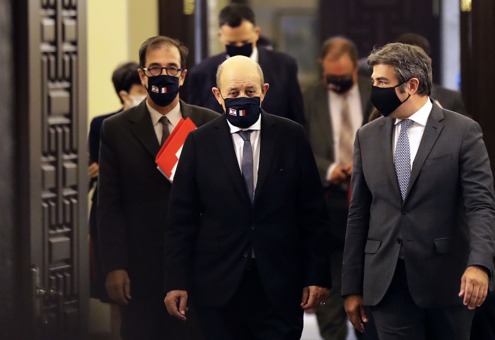 French Foreign Minister Jean-Yves Le Drian (C) wears a face mask with the Lebanese and French flags as he arrives at the governmental palace in Beirut for a meeting with the Lebanese prime minister, on July 23, 2020. AFP / JOSEPH EID