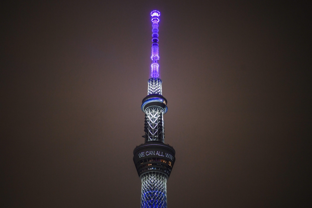 A general view shows the Tokyo Skytree illuminated in blue to pay tribute to medical workers as the city marks one year until the postponed Tokyo 2020 Olympic and Paralympic Games in Tokyo on July 23, 2020. Japan held subdued celebrations on July 23 to ma