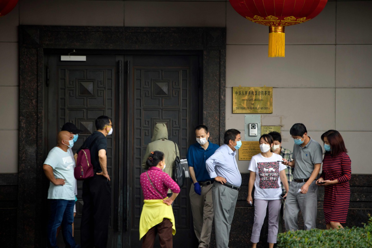 People attempt to talk to someone at the Chinese consulate in Houston on July 22, 2020. US-Chinese tensions, already rising because of the coronavirus pandemic and crackdown in Hong Kong, ratcheted up another notch on Wednesday as the US ordered the closu