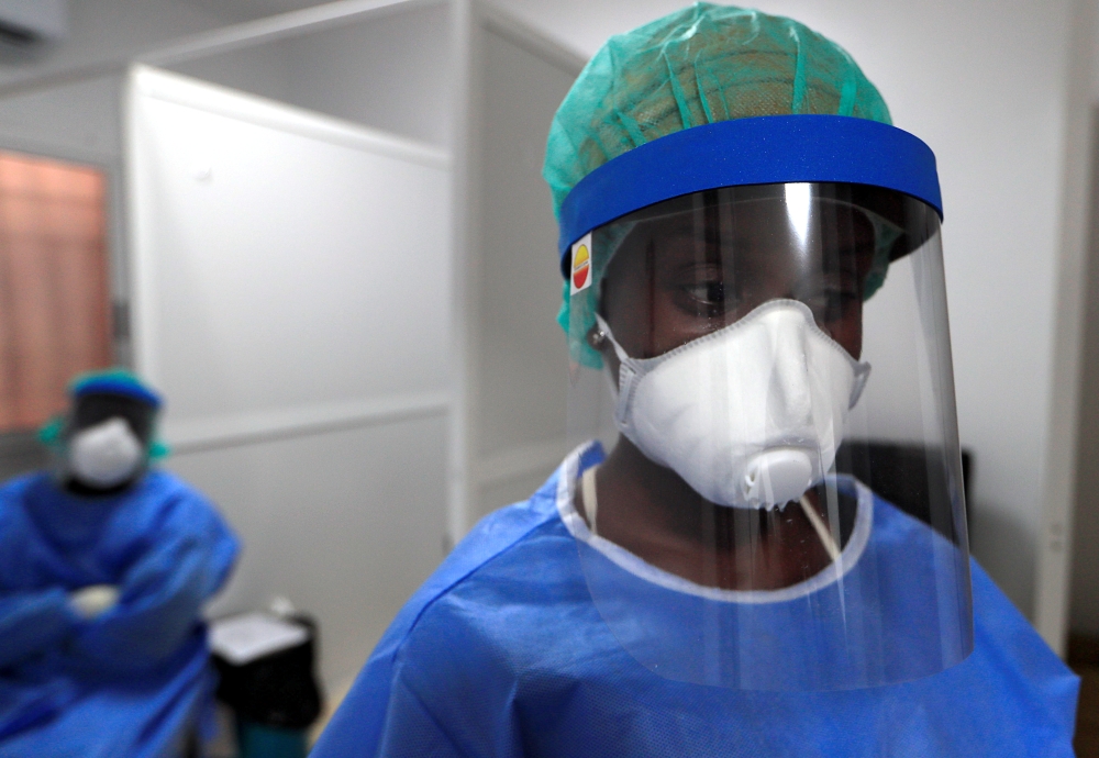 A healthcare worker wearing protective gear stands next to a testing booth for the coronavirus disease (COVID-19) at an Institute for Health Research, Epidemiological Surveillance and Training (IRESSEF) testing center, in Dakar, Senegal July 24, 2020. REU