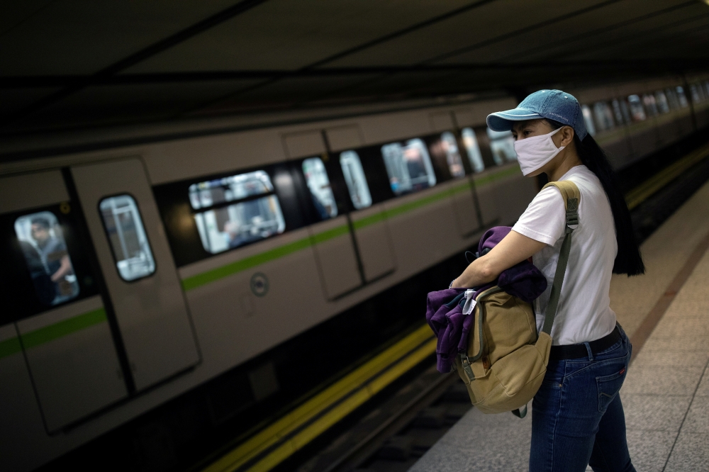 FILE PHOTO: A commuter wearing a protective face mask waits for a train at the metro station on Syntagma square, on the first day of easing of a nationwide lockdown against the spread of coronavirus disease (COVID-19), in Athens, Greece, May 4, 2020. REUT