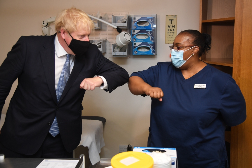 Britain's Prime Minister Boris Johnson bumps elbows with a staff member during his visit to the Tollgate Medical Centre in Becton, east London on July 24, 2020.. AFP / POOL / Jeremy Selwyn