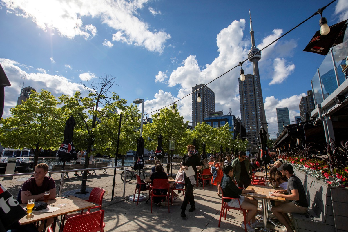 FILE PHOTO: People enjoy drinks and food at Amsterdam Brewhouse's patio, as the provincial phase 2 of reopening from the coronavirus disease (COVID-19) restrictions begins in Toronto, Ontario, Canada June 24, 2020. REUTERS/Carlos Osorio/File Photo