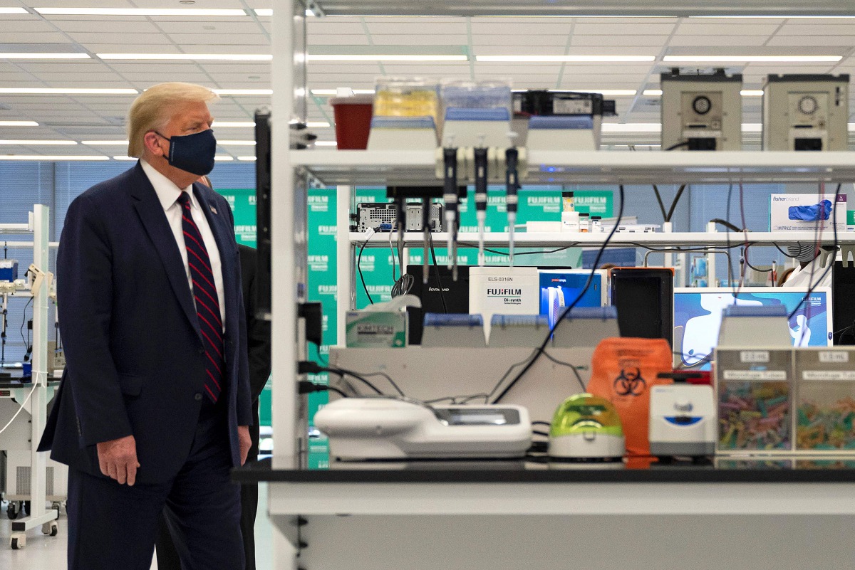 US President Donald Trump wears a mask, alongside Fujifilm Diosynth Biotechnologies CEO Martin Messon (R), as they tour a lab where they are making components for a potential vaccine at the Bioprocess Innovation Center at Fujifilm Diosynth Biotechnologies