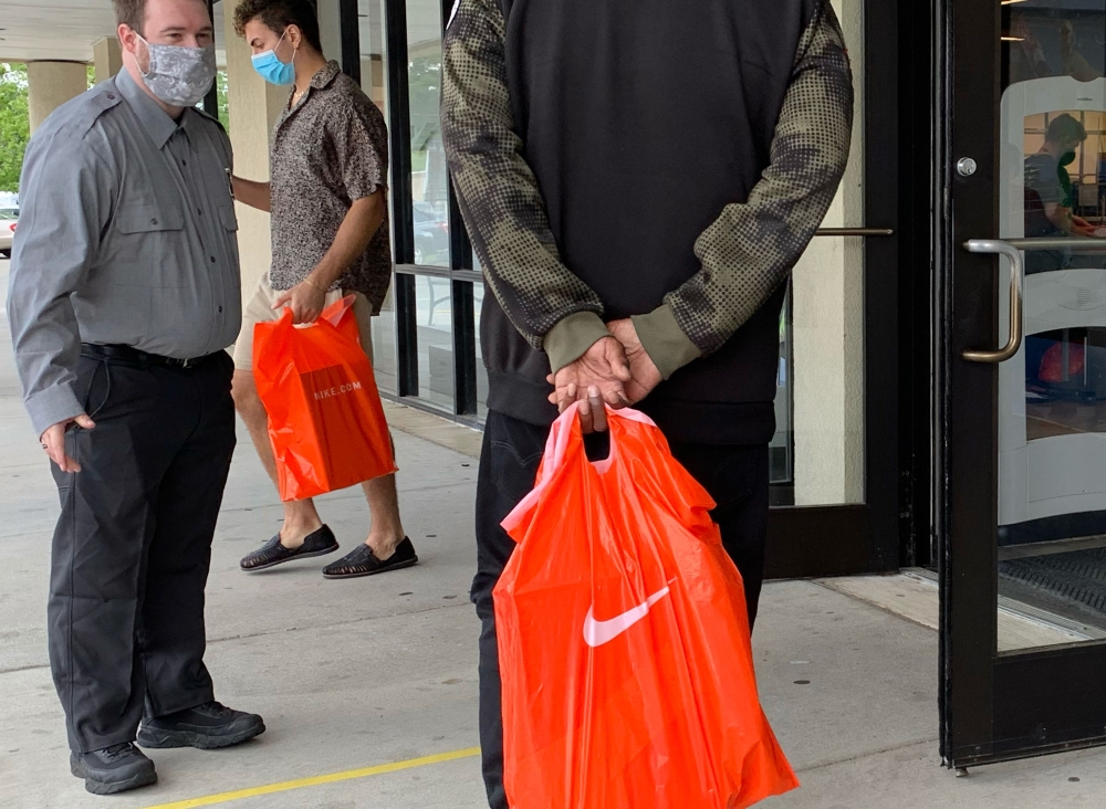 In this file photo taken on June 18, 2020, stand in line to get into the Nike Factory store at Queenstown Outlets in Queenstown, Maryland, during the coronavirus pandemic. Nike said on July 22, 2020, it expects to cut jobs as it announced a slew of new ex