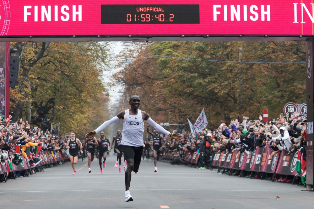 In this file photo taken on October 12, 2019, Kenya's Eliud Kipchoge, wearing the Nike AlphaFly prototype shoes, celebrates as he crosses the finish line at the end of his attempt to bust the mythical two-hour barrier for the marathon in Vienna. World Ath