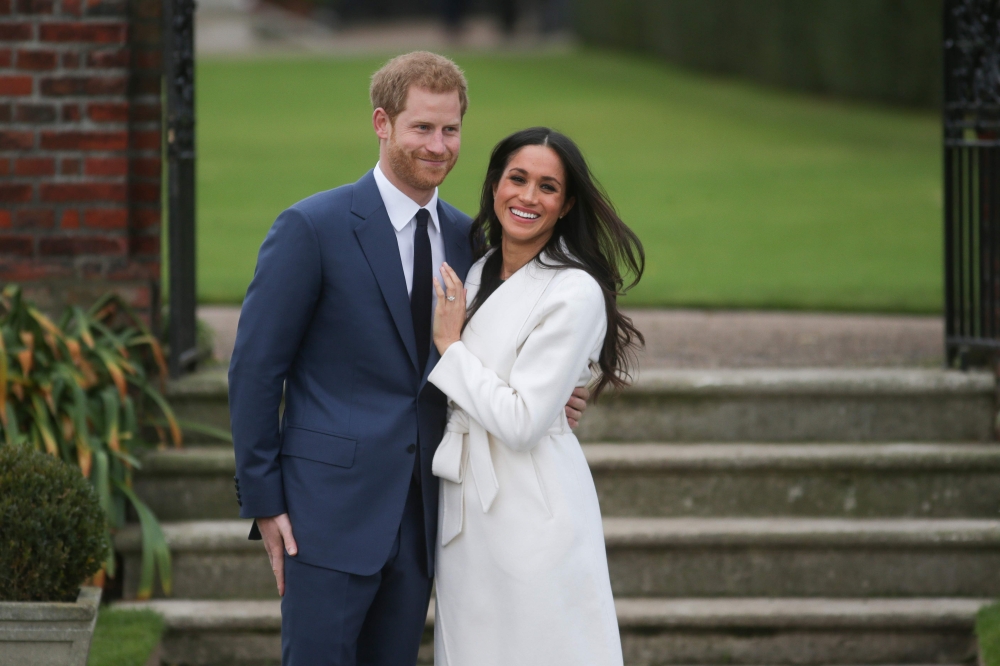 In this file photo taken on November 27, 2017 Britain's Prince Harry and his fiancée US actress Meghan Markle pose for a photograph in the Sunken Garden at Kensington Palace in west London on November 27, 2017, following the announcement of their engageme