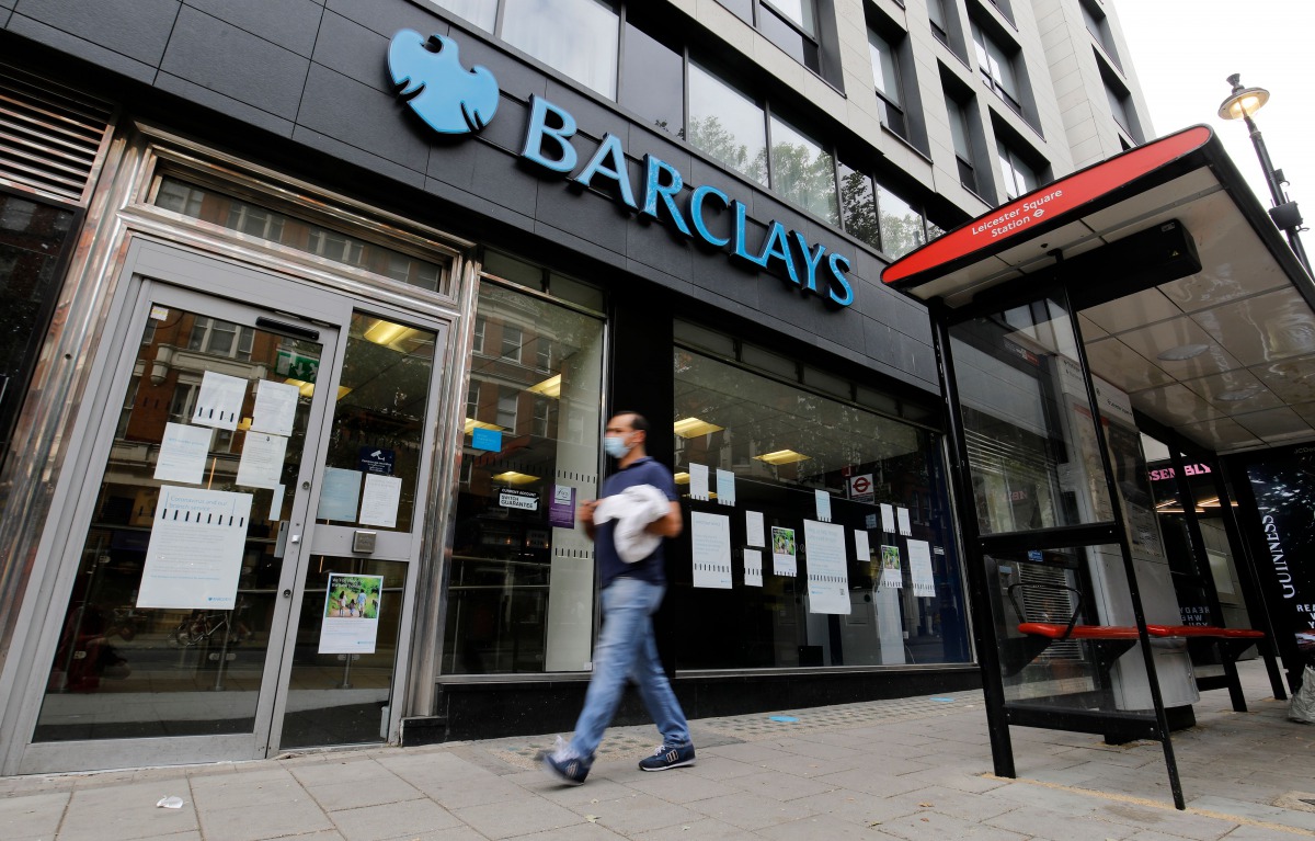 A pedestrian wearing a face mask or covering due to the COVID-19 pandemic, walks past a branch of a Barclays bank in central London on July 29, 2020./ AFP / Tolga AKMEN
