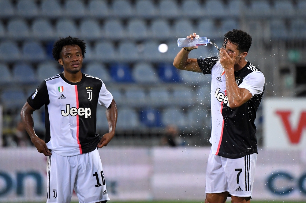 Juventus' Cristiano Ronaldo with Juan Cuadrado during the drinks break, as play resumes behind closed doors following the outbreak of the coronavirus disease (COVID-19) REUTERS/Alberto Lingria