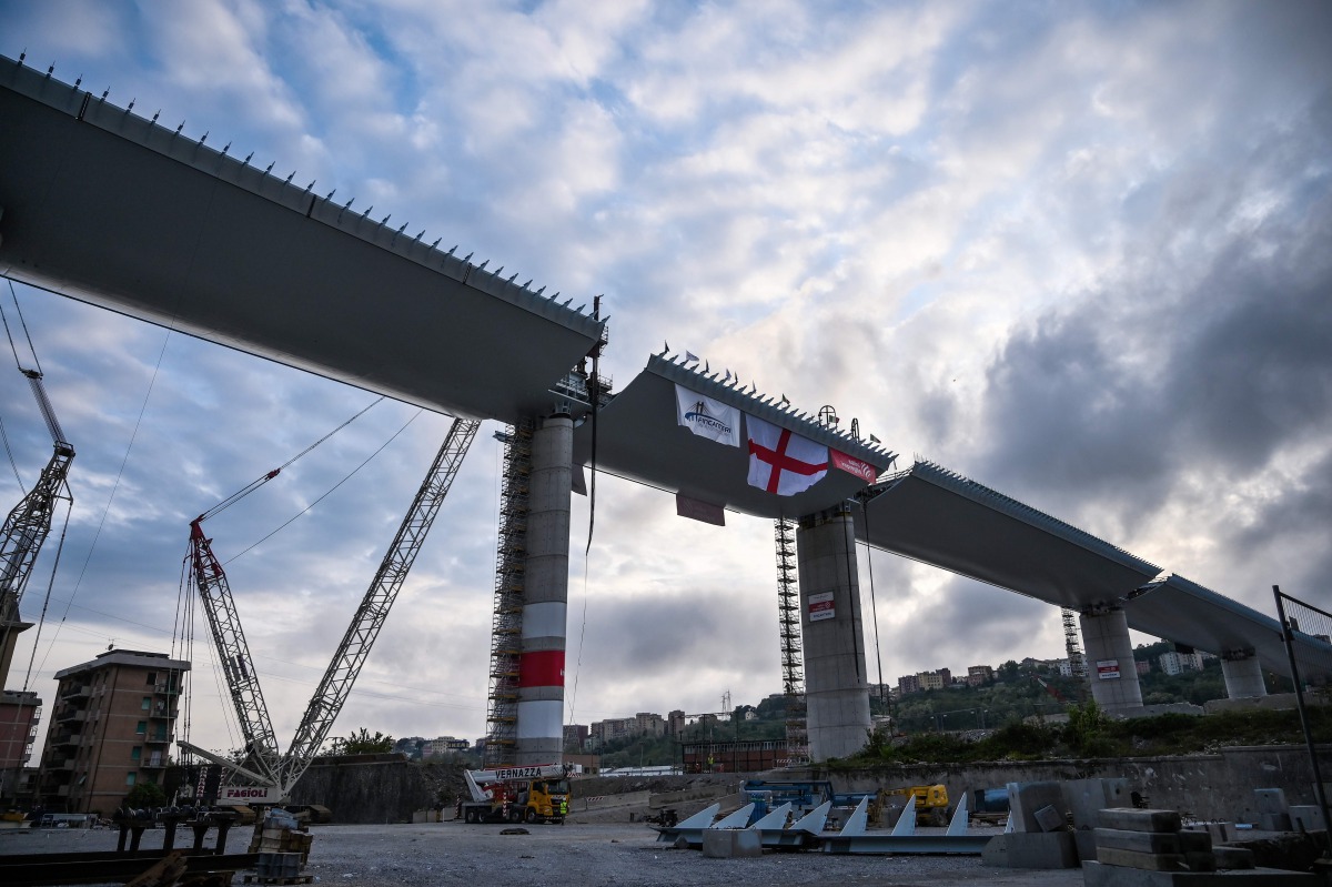 (FILES) This file photo taken on April 27, 2020 shows a view of the last 44 meter long span (Top C) that is being hoisted between columns 10 and 11 on the bridge's eastern side in Genoa, during the country's lockdown aimed at curbing the spread of the COV