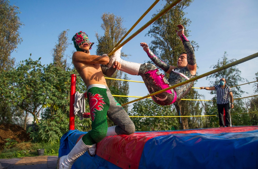 Wrestlers perform during the Chinampalucha event organized by Mexican wrestlers in the chinampas of Xochimilco in Mexico City, on August 1, 2020, as rings remain closed due to the COVID-19 coronavirus pandemic. / AFP / CLAUDIO CRUZ