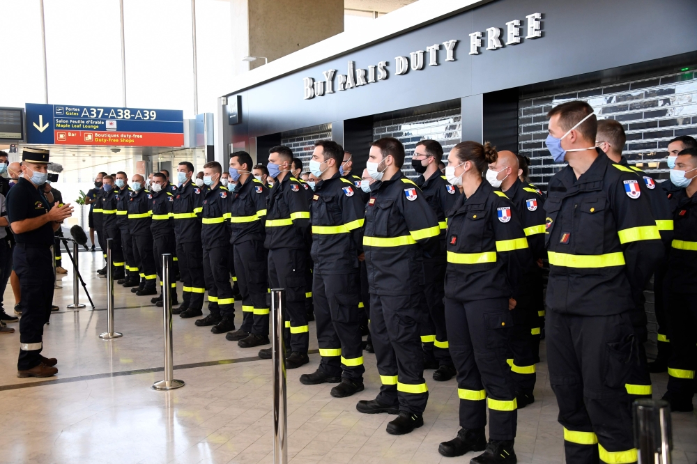 French colonel Stanislas Rouqueyrol (L) delivers a speech to personnel of French Securite Civile (Civil Security) in Roissy airport, near Paris, on August 5, 2020. AFP / Bertrand GUAY
