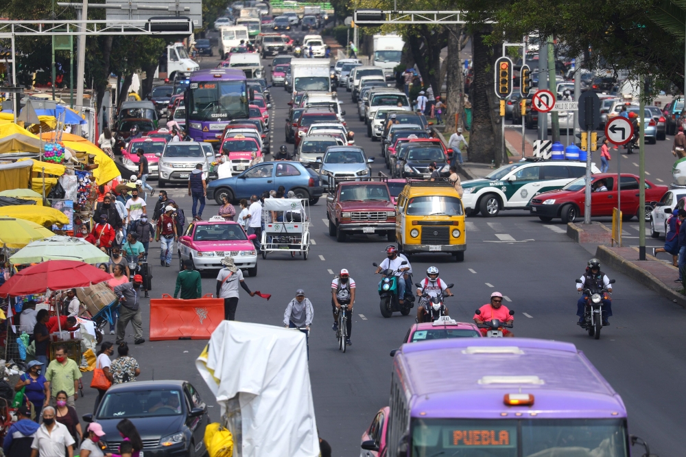 People and cars are pictured on an avenue during the start of gradual reopening of commercial activities, as the coronavirus disease (COVID-19) outbreak continues, in Mexico City, Mexico, July 31, 2020. REUTERS/Edgard Garrido