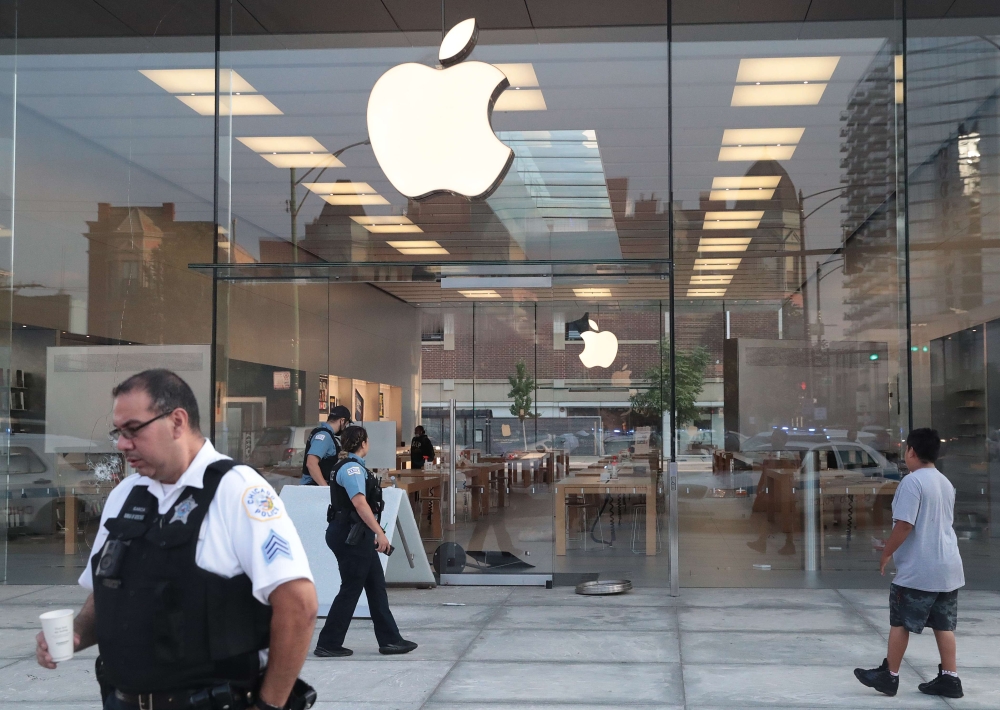 CHICAGO, ILLINOIS - AUGUST 10: Police inspect an Apple store that had windows broken after parts of the city had widespread looting and vandalism, on August 10, 2020 in Chicago, Illinois. Police made several arrests during the night of unrest and recovere