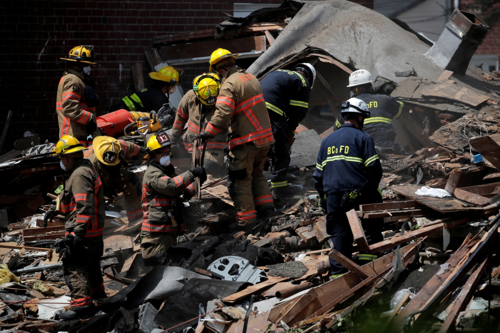 Fire fighters look for survivors at the scene of an explosion in a residential area of Baltimore, Maryland, U.S., August 10, 2020. REUTERS/Carlos Barria