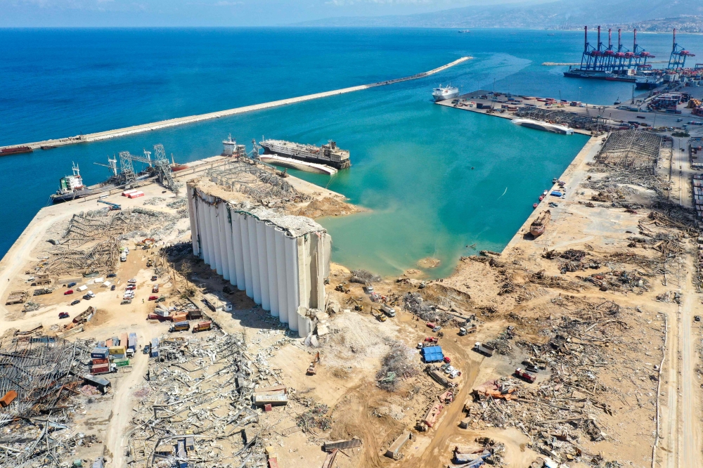 An aerial view taken on August 9, 2020, shows a general view of the port of Beirut, the damaged grain silo and the crater caused by the colossal explosion of a huge pile of ammonium nitrate that had languished for years in a port warehouse, leaving scores
