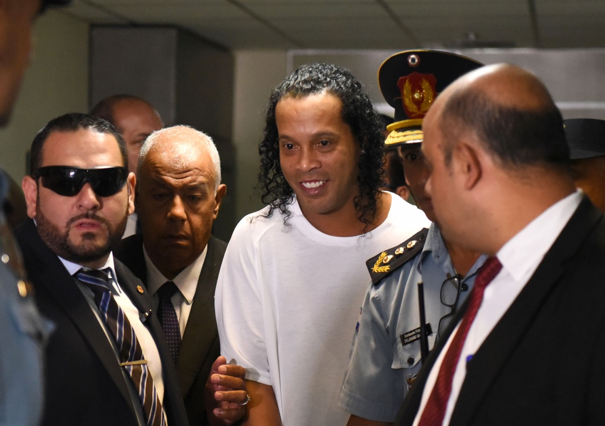 (FILES) In this file photo taken on March 06, 2020, Brazilian retired football player Ronaldinho (C) arrives at Asuncion's Justice Palace to testify about his irregular entry to the country, in Asuncion. / AFP / Norberto DUARTE
