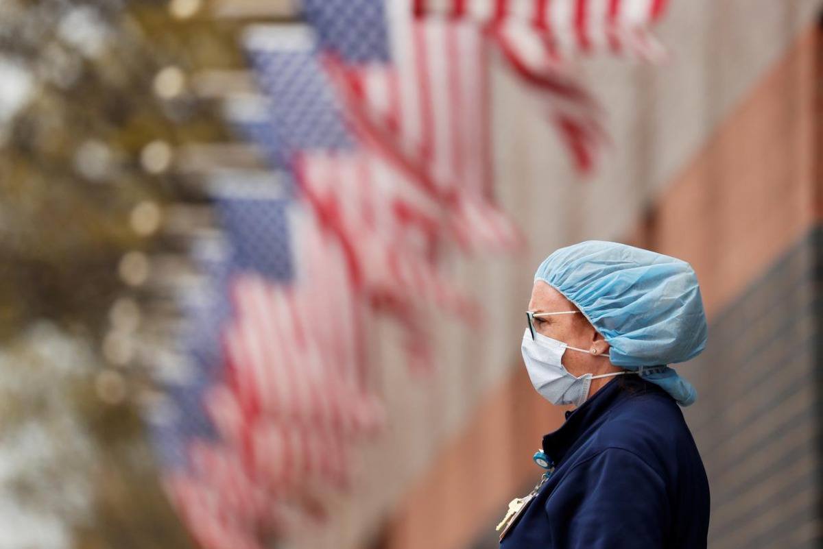 FILE PHOTO: A nurse wearing personal protective equipment watches an ambulance driving away outside of Elmhurst Hospital during the ongoing outbreak of the coronavirus disease (COVID-19) in the Queens borough of New York, U.S., April 20, 2020. REUTERS/Luc