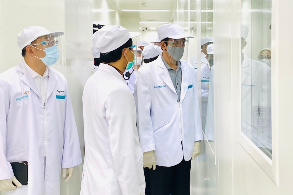 This handout photo taken and released on August 11, 2020 by Presidential Palace shows President Joko Widodo (R) visiting the Bio Farma Pharmacy that produce vaccines for COVID-19 coronavirus in Bandung, West Java. Indonesia on August 11, 2020 launched hum