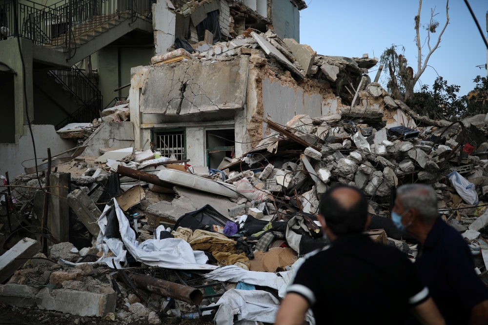 Locals look at a destroyed house where the wife and two of the daughters of Syrian refugee Ahmed Staifi were killed following a massive explosion, in Beirut, Lebanon, August 11, 2020. REUTERS/Alkis Konstantinidis