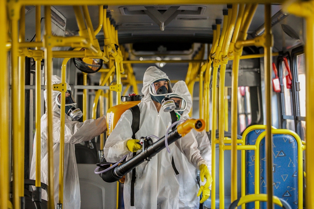 Military personnel from the Brazilian Armed Forces sanitize a bus at the Santa Candida bus terminal to combat the spread of the the novel coronavirus, COVID-19, in Curitiba, Parana State, Brazil, on August 10, 2020. / AFP / Daniel CASTELLANO