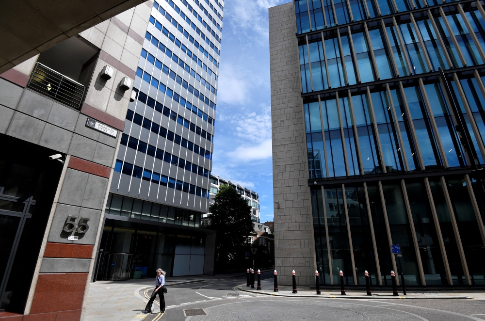 A woman walks through the financial district in the City of London, following the outbreak of the coronavirus disease (COVID-19), in London, Britain July 13, 2020. REUTERS/Toby Melville/File Photo