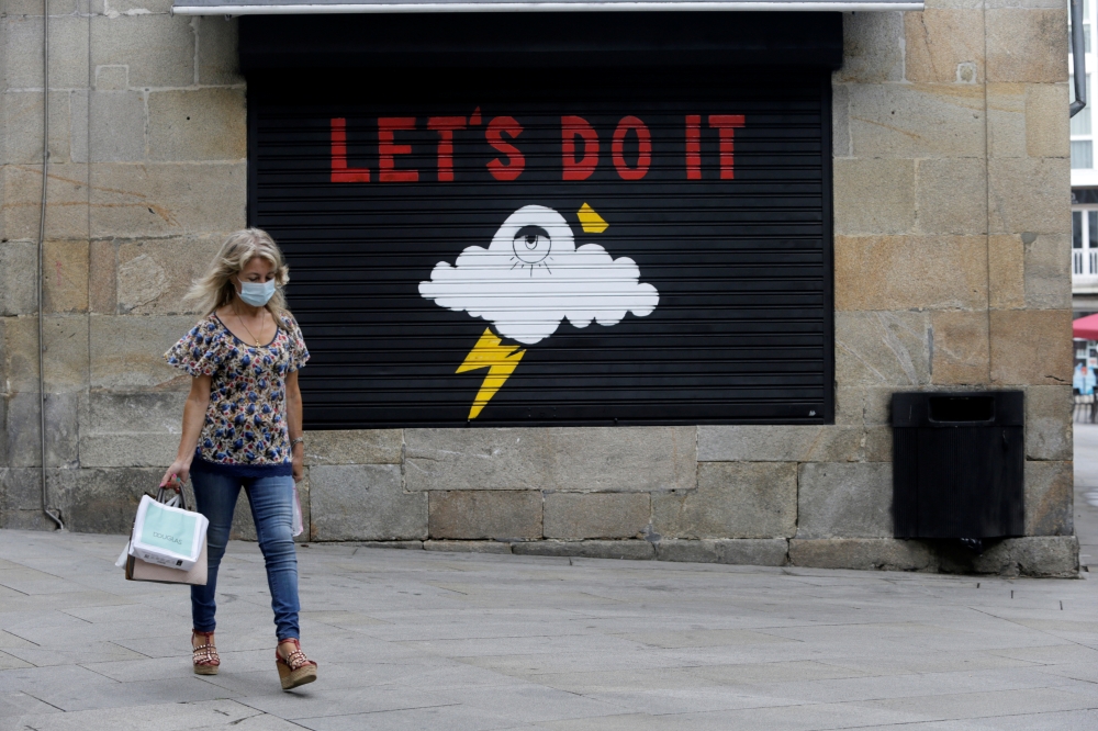 A woman in a protective mask walks during the coronavirus disease (COVID-19) pandemic in Pontevedra, Spain, August 13, 2020. REUTERS/Miguel Vidal