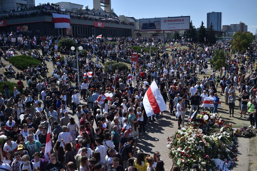 Belarus opposition supporters gather on a roof near the Pushkinskaya metro station where Alexander Taraikovsky, a 34-year-old protester died on August 10, during their protest rally in central Minsk, on August 15, 2020.  AFP / Sergei GAPON