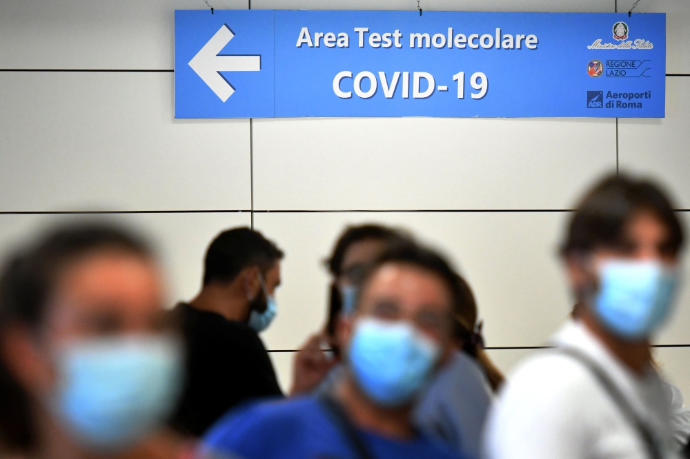 Passengers queue to be screened for Covid-19 at a testing station set up at Fiumicino airport, near Rome, on August 16, 2020. Italy has introduced mandatory Covid-19 (novel coronavirus) testing for anyone arriving from Croatia, Greece, Spain and Malta and