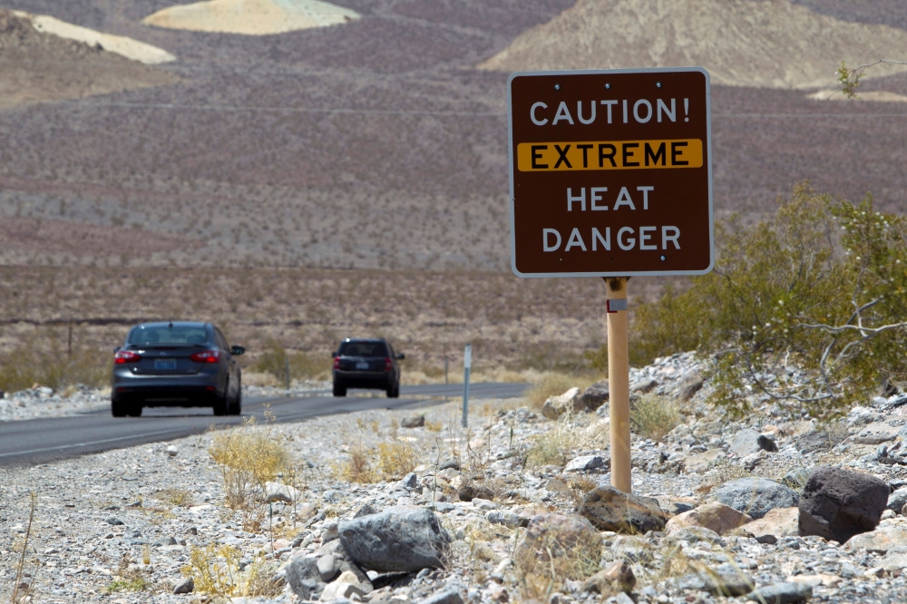 A sign warns of extreme heat as tourists enter Death Valley National Park in California June 29, 2013. REUTERS/Steve Marcus/File Photo