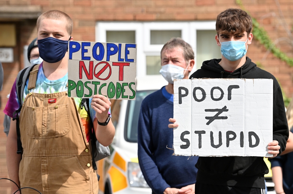 Students hold placards as they protest outside of the constituency office for Gavin Williamson, Conservative MP for South Staffordshire and Britain's current Education Secretary, in Codsall near Wolverhampton, central England on August 17, 2020 .AFP / Pau