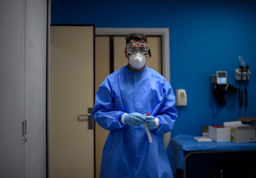 A healthcare worker holds a sample at a temporary testing centre for the novel coronavirus in Madrid on August 17, 2020.  / AFP / OSCAR DEL POZO