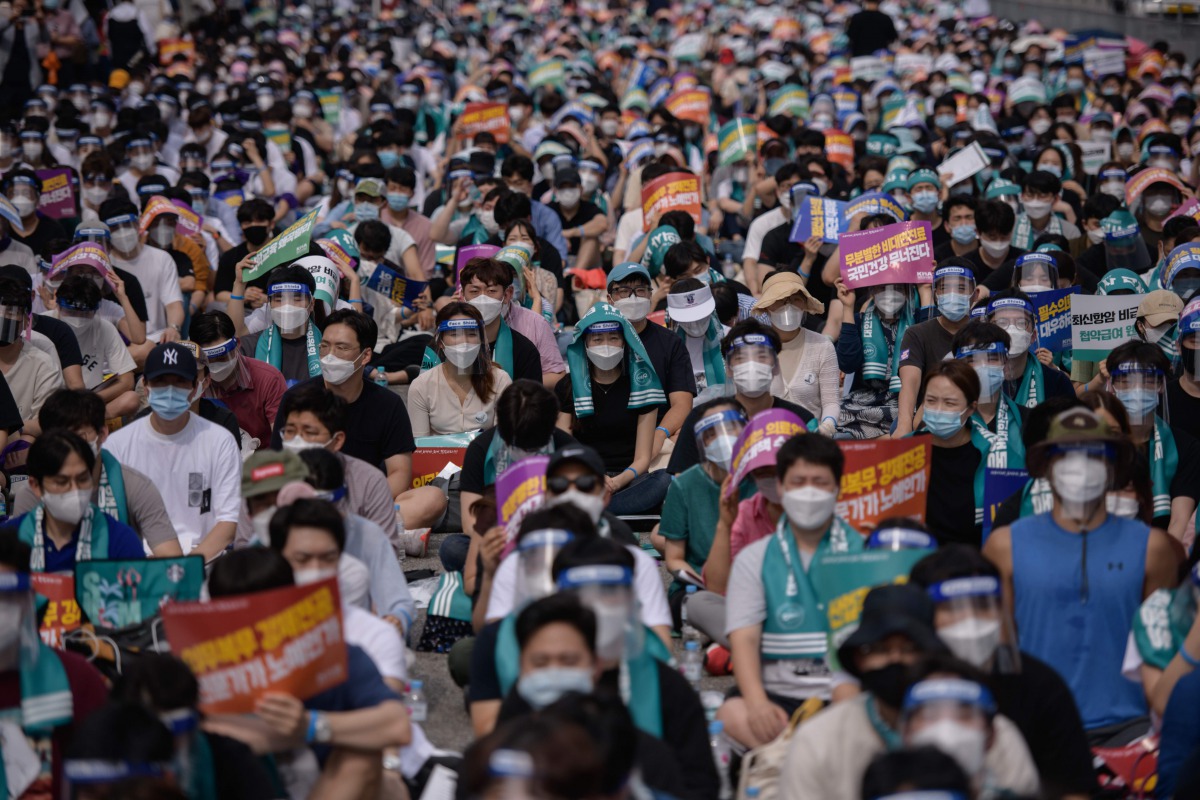 Doctors, medical students and healthcare professionals wearing face masks and protective equipment as part of preventative measures against the COVID-19 coronavirus attend a rally to protest against a government proposal to increase its annual intake of m